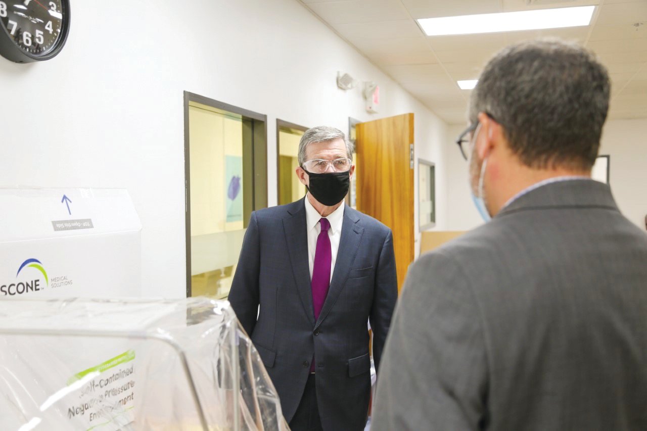Gov. Roy Cooper speaks with executives from Pittsboro industry Gilero during a visit there Thursday. Gilero is one of the state's leading producers of PPE (personal protective equipment).