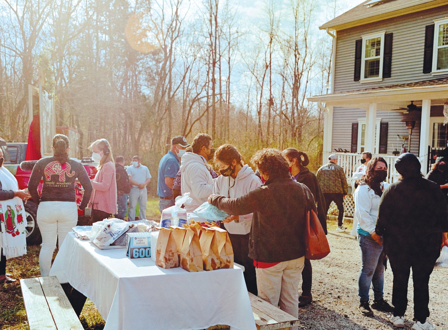 A family set up a table lined with bags filled with Colombian empanadas and trays with bunched meals. There were also cups of coffee available for those who wanted it.