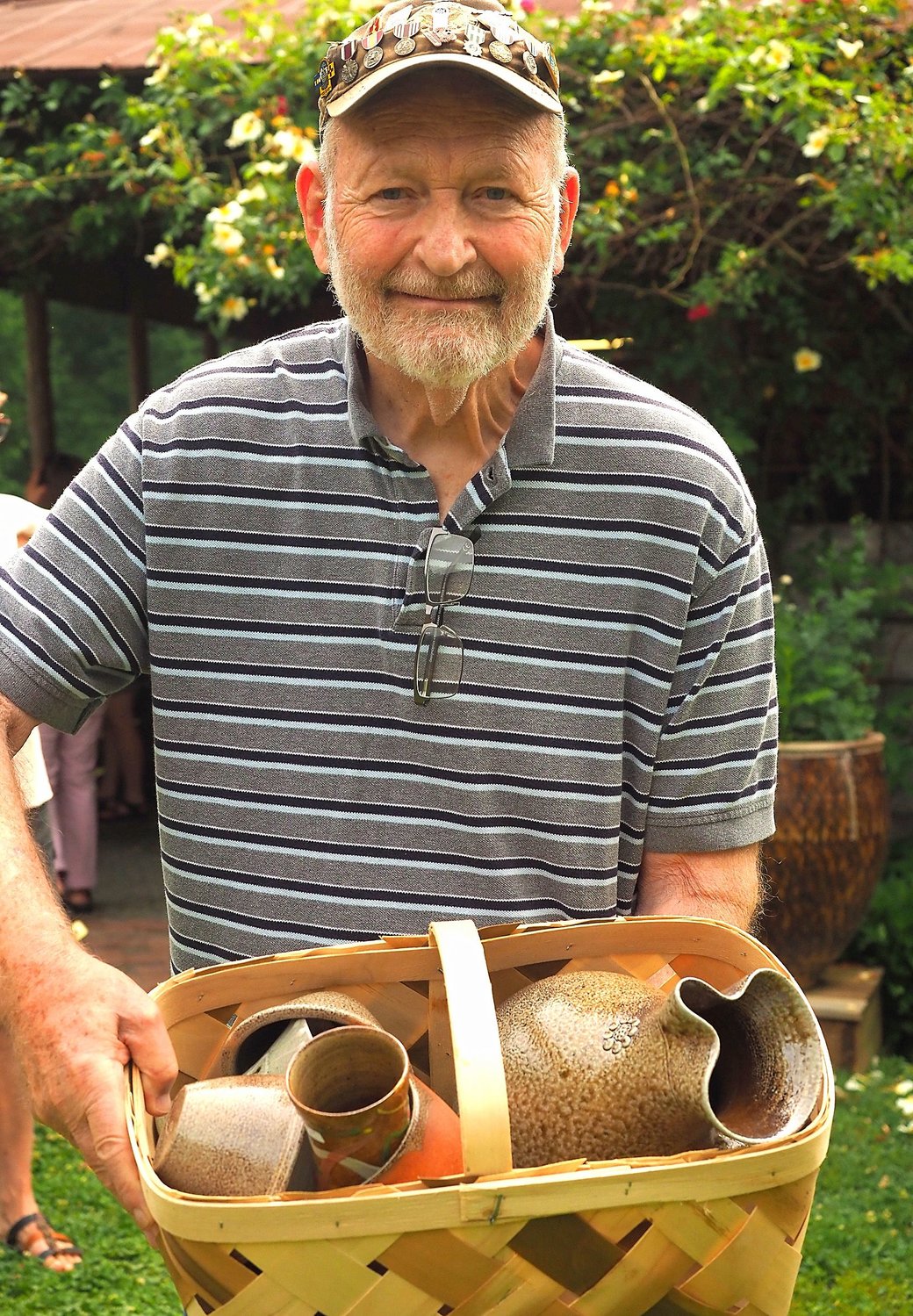 Retired veteran Claud Sanford of Canton, Georgia, is shown with a basket of pots he’s picked out for purchase at Mark Hewitt’s kiln opening.