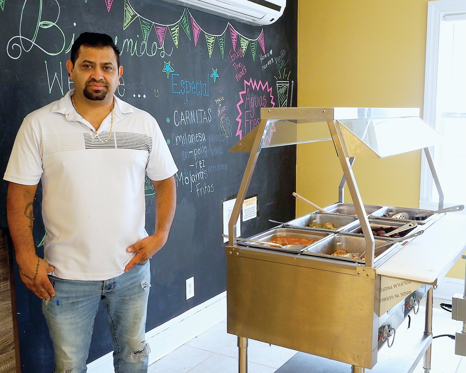 San Marcos Taqueria y Buffet's owner, Bernardo Gallegos Rodriguez, showcases the restaurant's new buffet station on Saturday. Located at 315 East Third Street, San Marcos first opened for business on May 15.