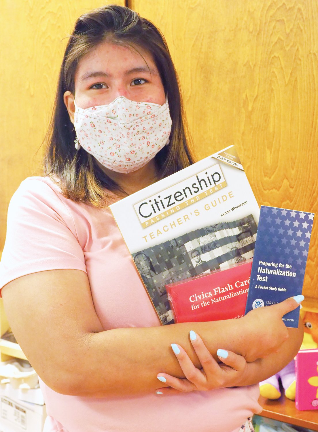 Leslie Ocampo, Chatham Literacy's student and program coordinator, holds up the nonprofit's citizenship teaching materials. She manages the nonprofit's citizenship program, which has been helping Chatham's immigrants become U.S citizens since 2009.