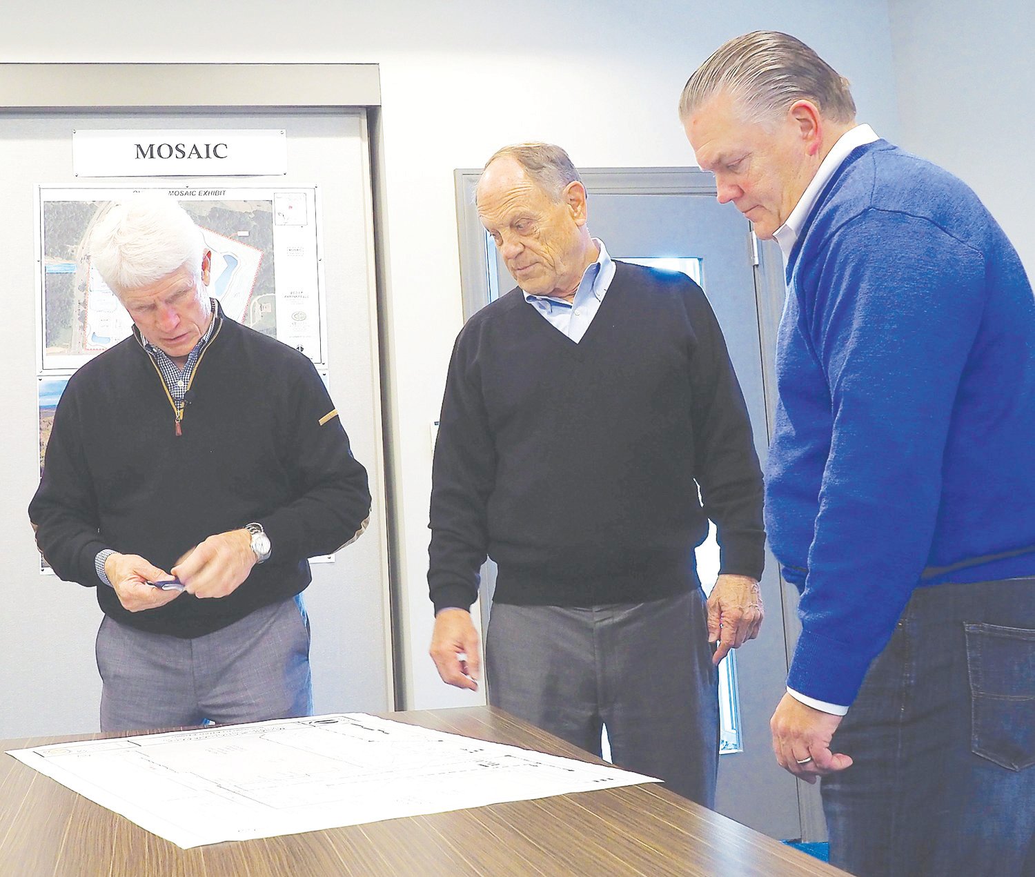 Chatham Park developers Julian 'Bubba' Rawl (left) and Tim Smith (center) examine plans for Mosaic with its developer, Kirk Bradley.