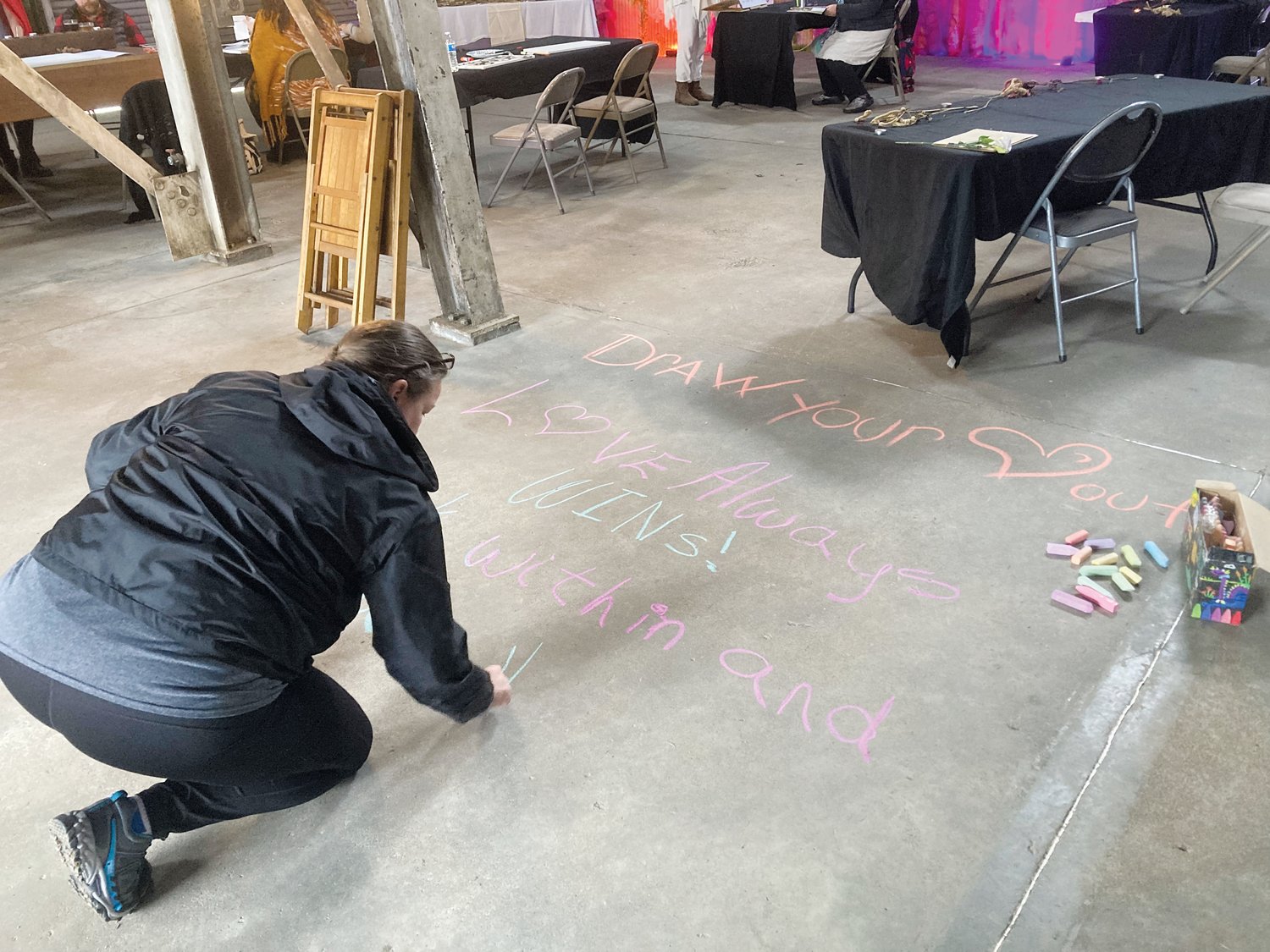 A woman using chalk during the visual art session at Death Faire.