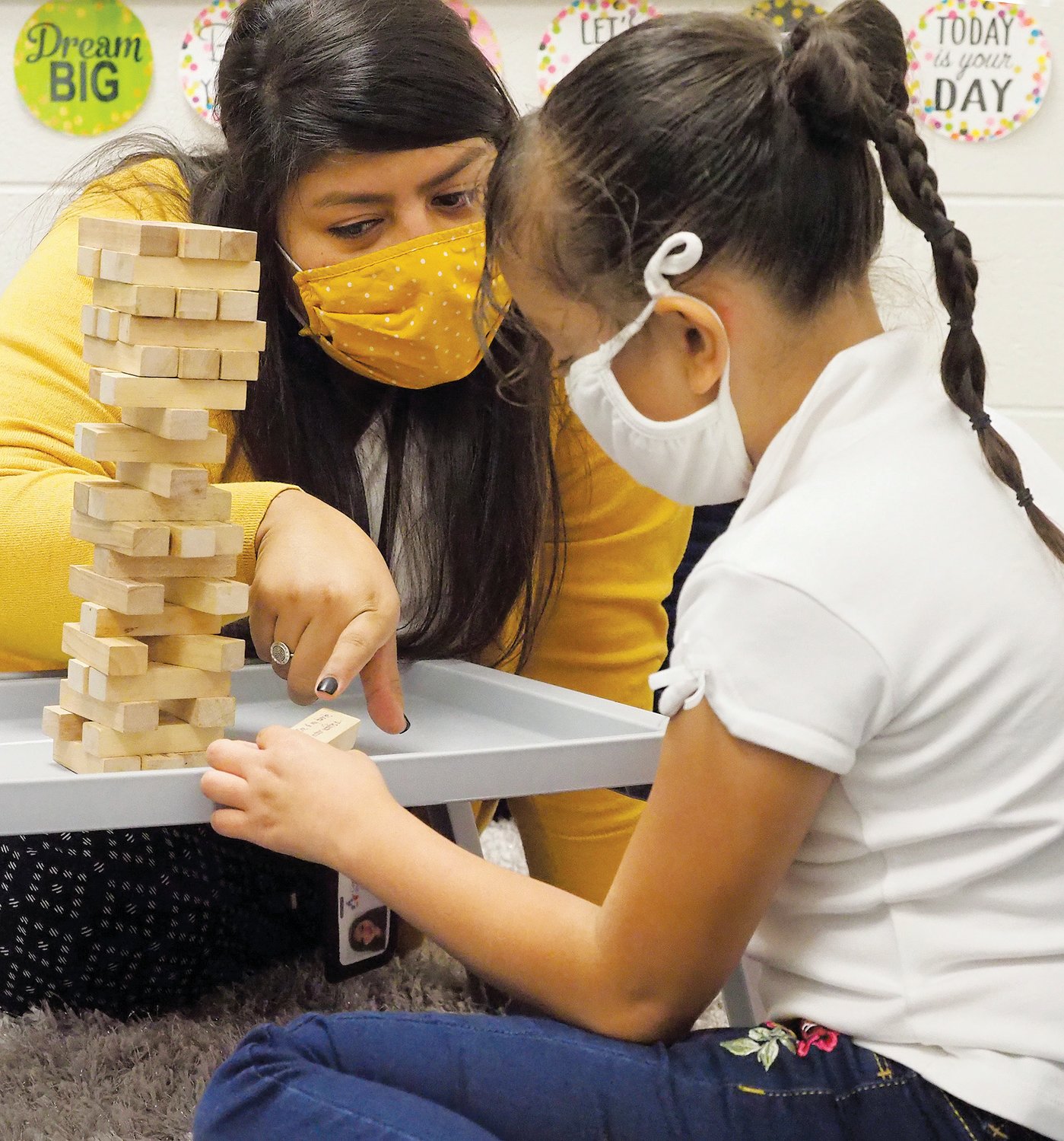 Eva Depaz, a CIS student support specialist at Virginia Cross Elementary School, plays a game with Yosary, a 2nd grader, during one of their sessions together in mid-October. The game allows each person to get to know the other: After building a tower out of wooden blocks, each player takes out a block and answers the question on each block until the tower collapses.