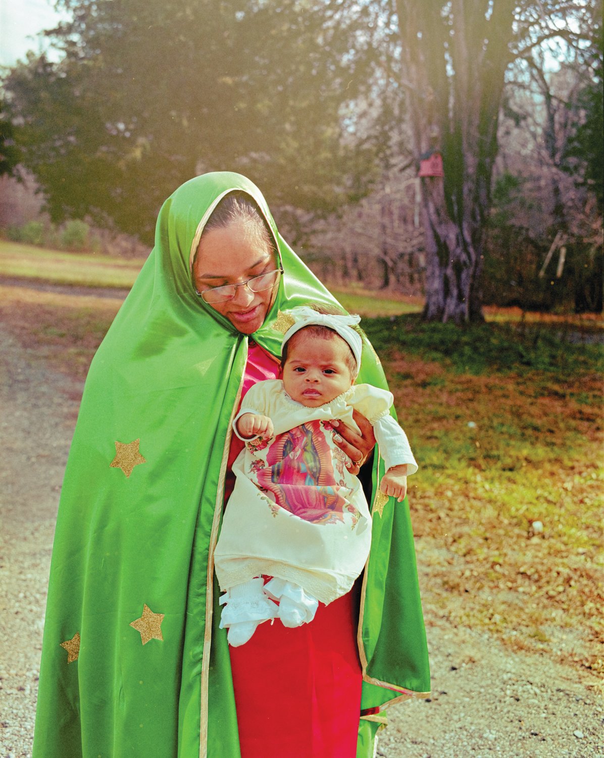 Cecilia Esquivel holds her daughter, Evelyn Hernandez, while dressed as the Virgin of Guadalupe in honor of the day’s pilgrimage last year in Siler City. Because of the pandemic, St. Julia Catholic Church held a scaled-down feast day celebration in 2020.