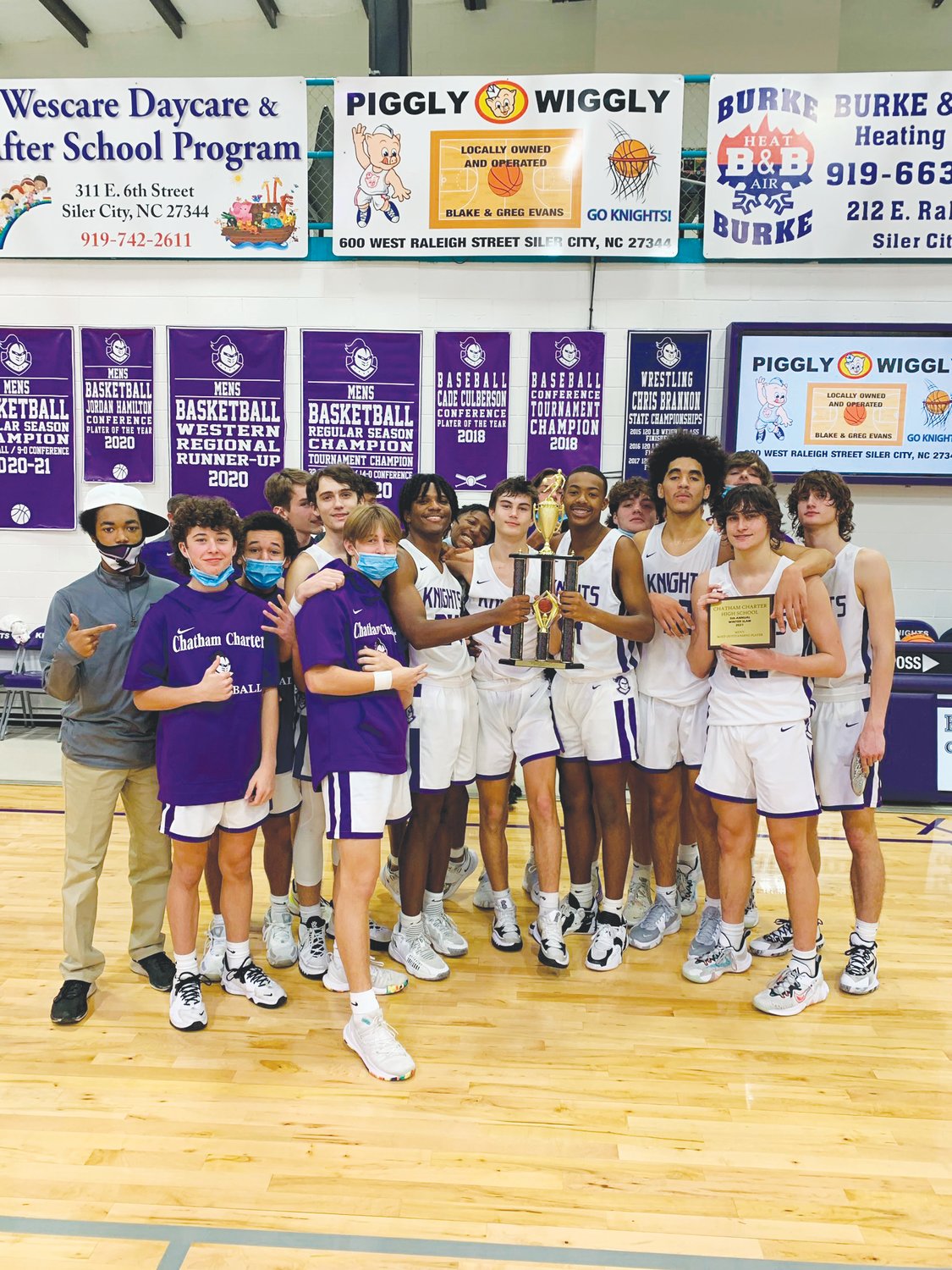 The Chatham Charter men's basketball team poses for photos after defeating the Research Triangle Raptors, 60-59, in the championship game of the 2021 Chatham Charter Winter Slam on Dec. 22.