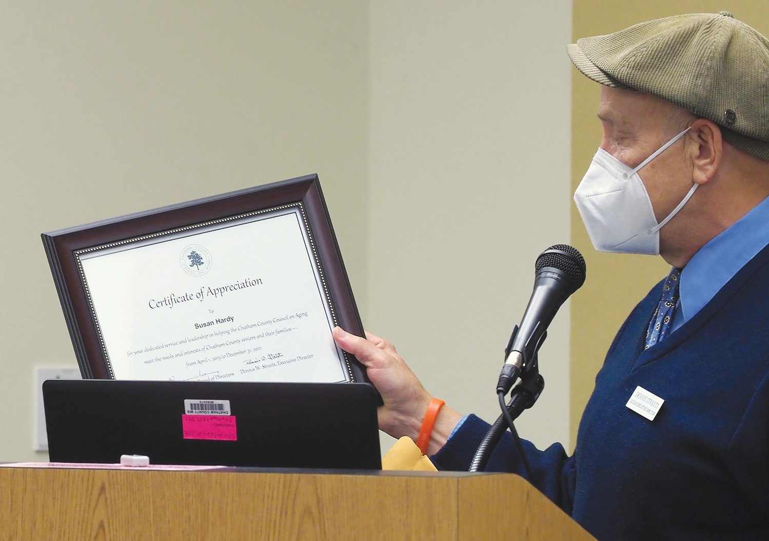 Chatham County Council on Aging Director Dennis Streets reads a certificate of appreciation for Susan Hardy at last Thursday's retirement event in Pittsboro.
