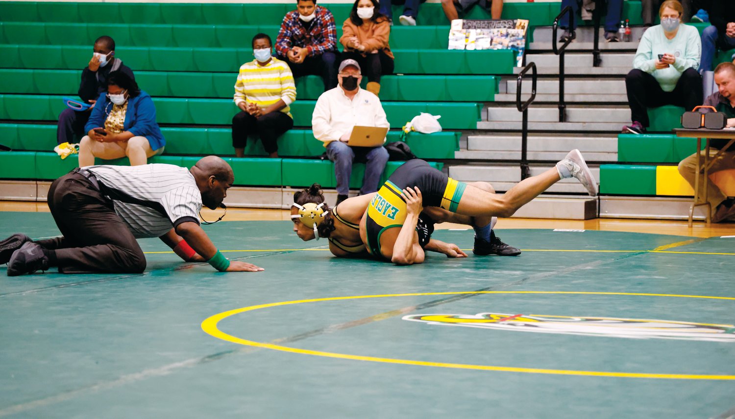 Northwood's Ron Walker (gold headgear) stacks up Eastern Alamance's Jahzion Patterson for a first period fall at 145 pounds during the Chargers' 42-36 victory over the Eagles last Thursday.