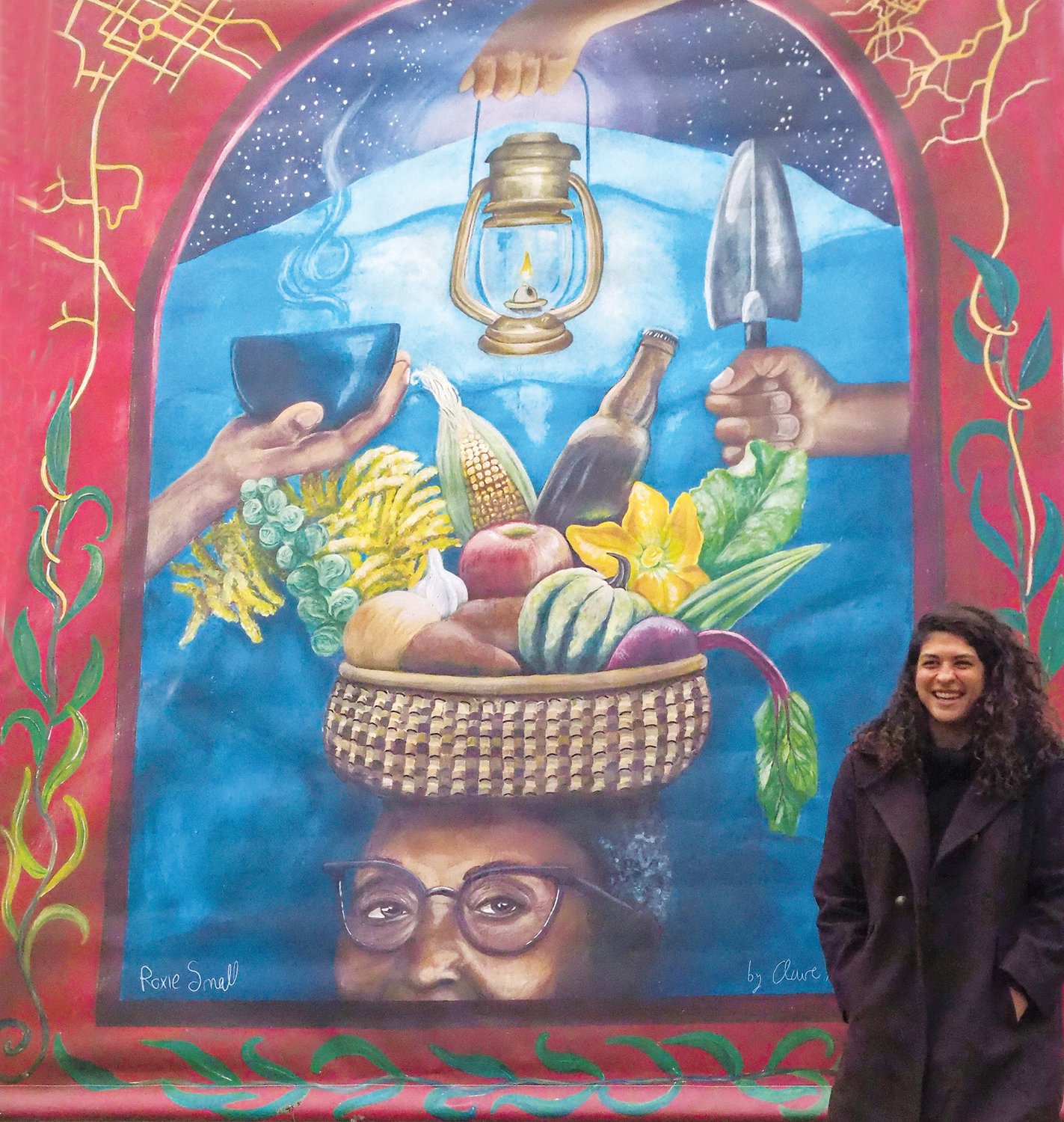 Local artist Claire Alexandre standing next to her mural at Chatham Ciderworks, which was unveiled on Sunday. .