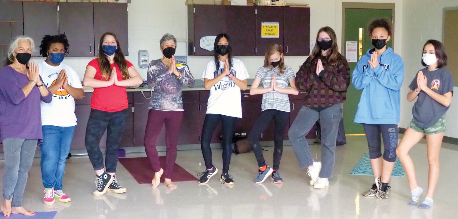 Seventh graders at George Moses Horton Middle School enjoy yoga classes as part of a Communities In Schools outreach program. From left: instructor Kim Serden Caraganis, Mariah R., Morgaine E., instructor Marcia Cordova-Roth, Jada E., Mia D., Ava B., Stella L. and Annagrace Z. There are many physical and mental benefits of practicing yoga, including calming the mind and improving balance.