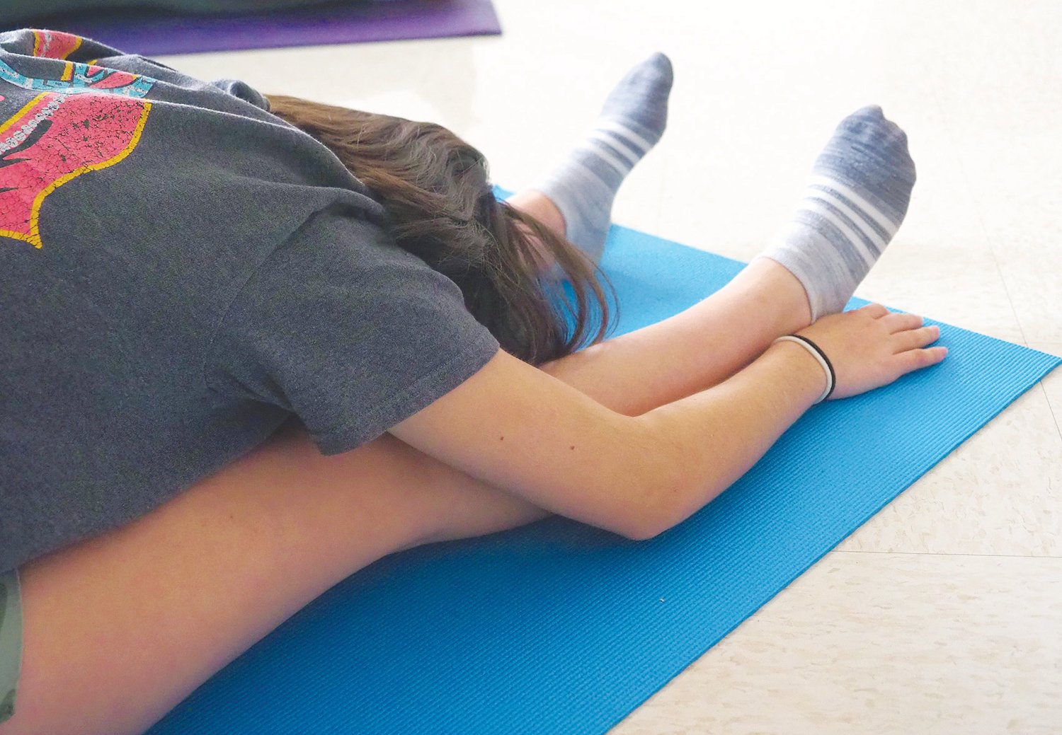 Student Annagrace Z. goes into a pose that gently stretches her body, builds stamina and calms her mind.