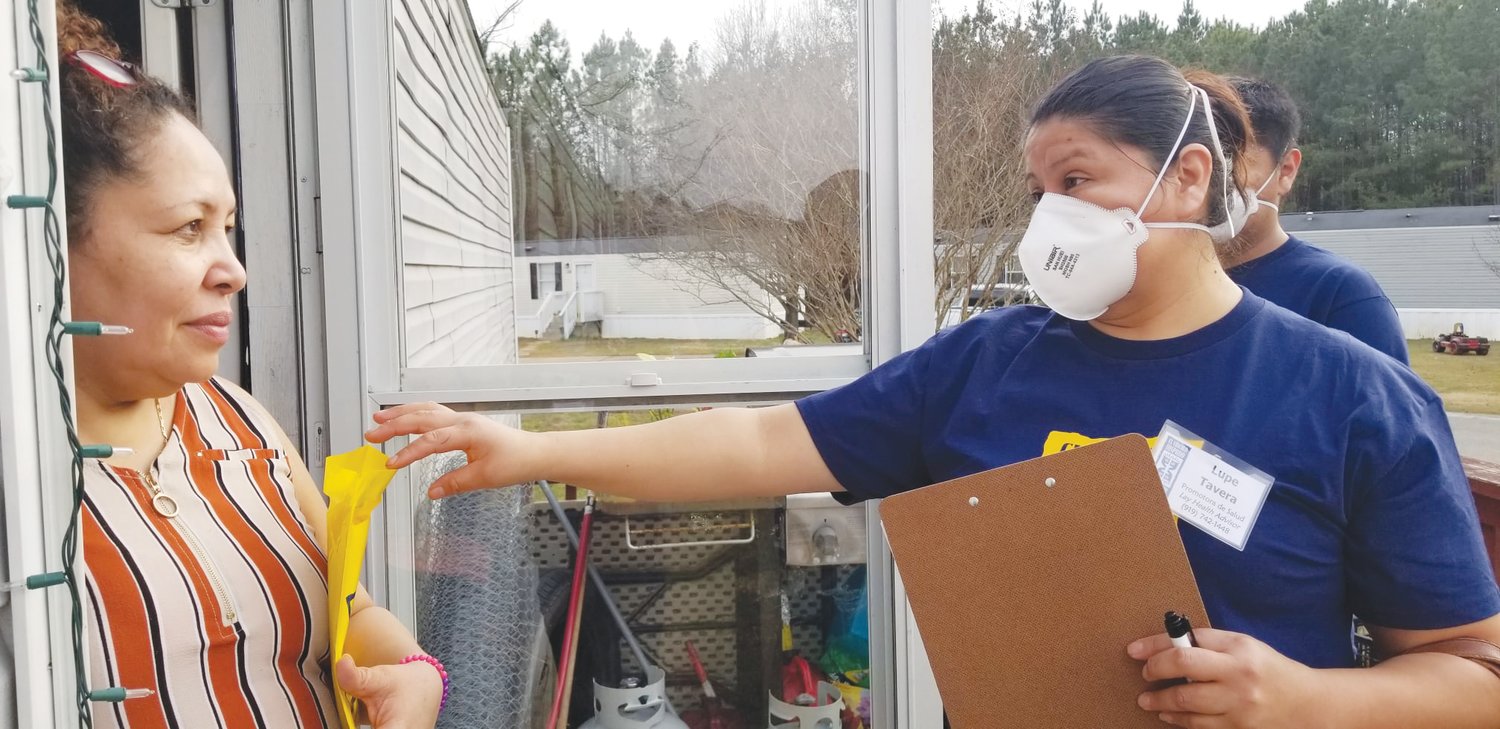 COVID-19 Lay Health Advisors Lupe Tavera (right) and Ervin Martinez, her son, begin knocking on doors last month in Siler City's Santa Fe Circle and Country Living neighborhoods.