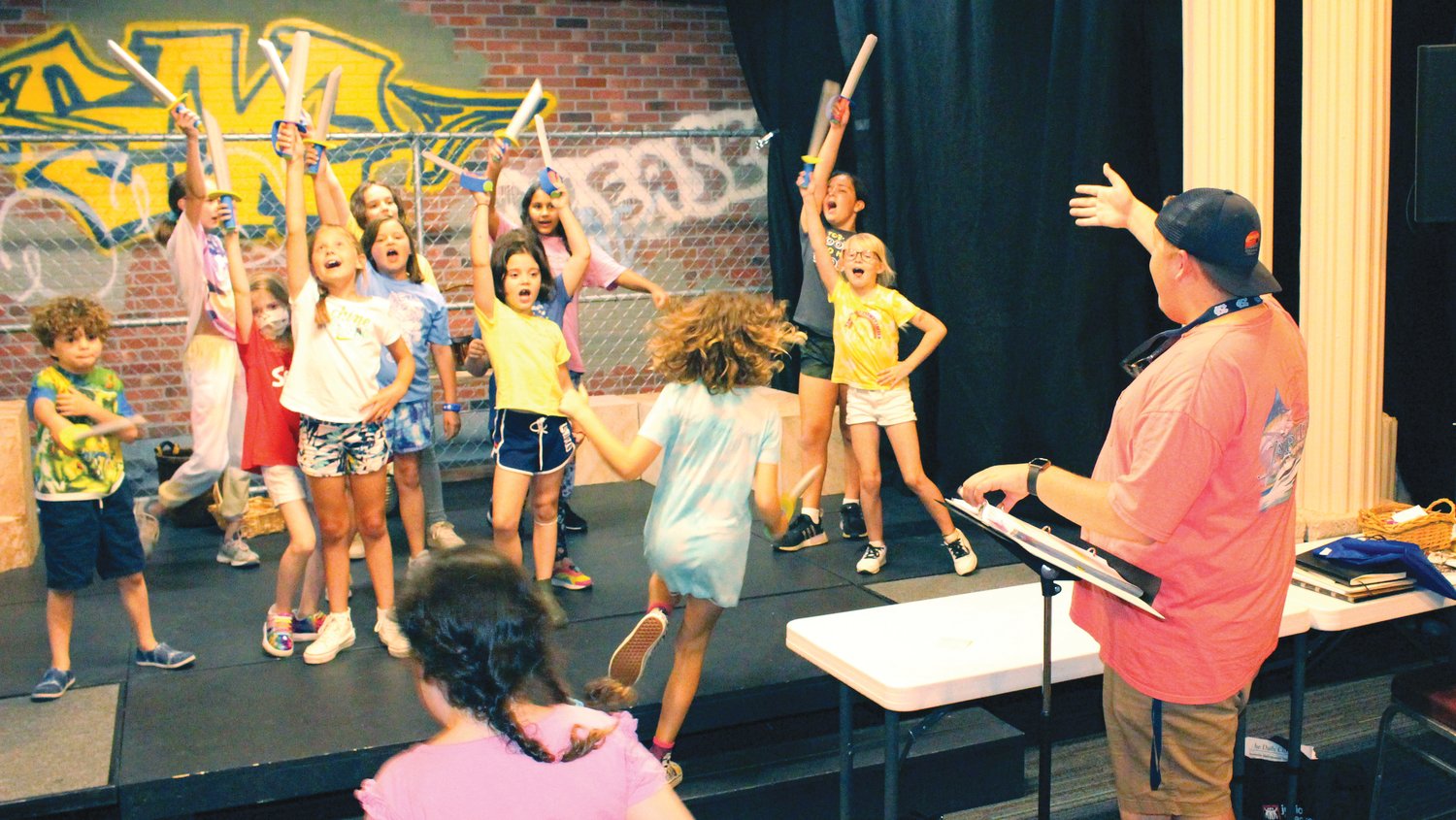 Pittsboro Youth Theater's Parker Harris directs the cast during a rehearsal of 'Young Aladdin.'