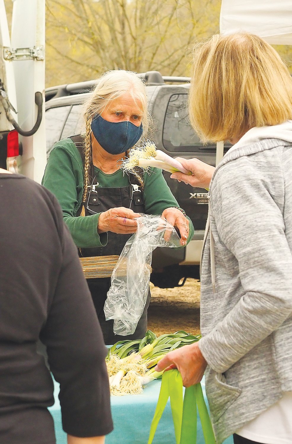 Cathy Jones of Perry-winkle Farm sells freshly-harvested leeks at her booth in Fearrington.