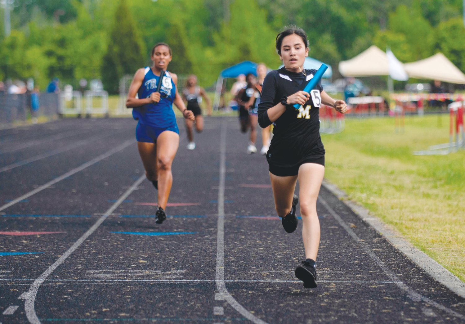Jordan-Matthews senior Jasmine Basilio (in black) crosses the finish line in the women's 4x400-meter relay during the NCHSAA 2A.Mideast Regionals at Franklinton High School last Saturday. Basilio helped lead the relay team to a gold-medal win, qualifying it for states.