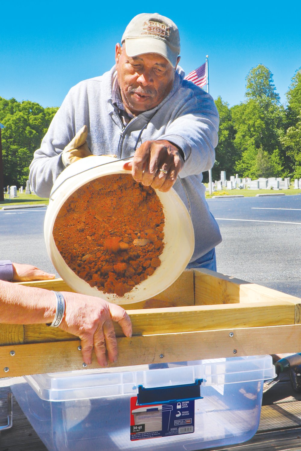 Kenneth Turrentine helps prepare soil from the lynching sites of the five Chatham residents honored and memorialized in Saturday's ceremony.