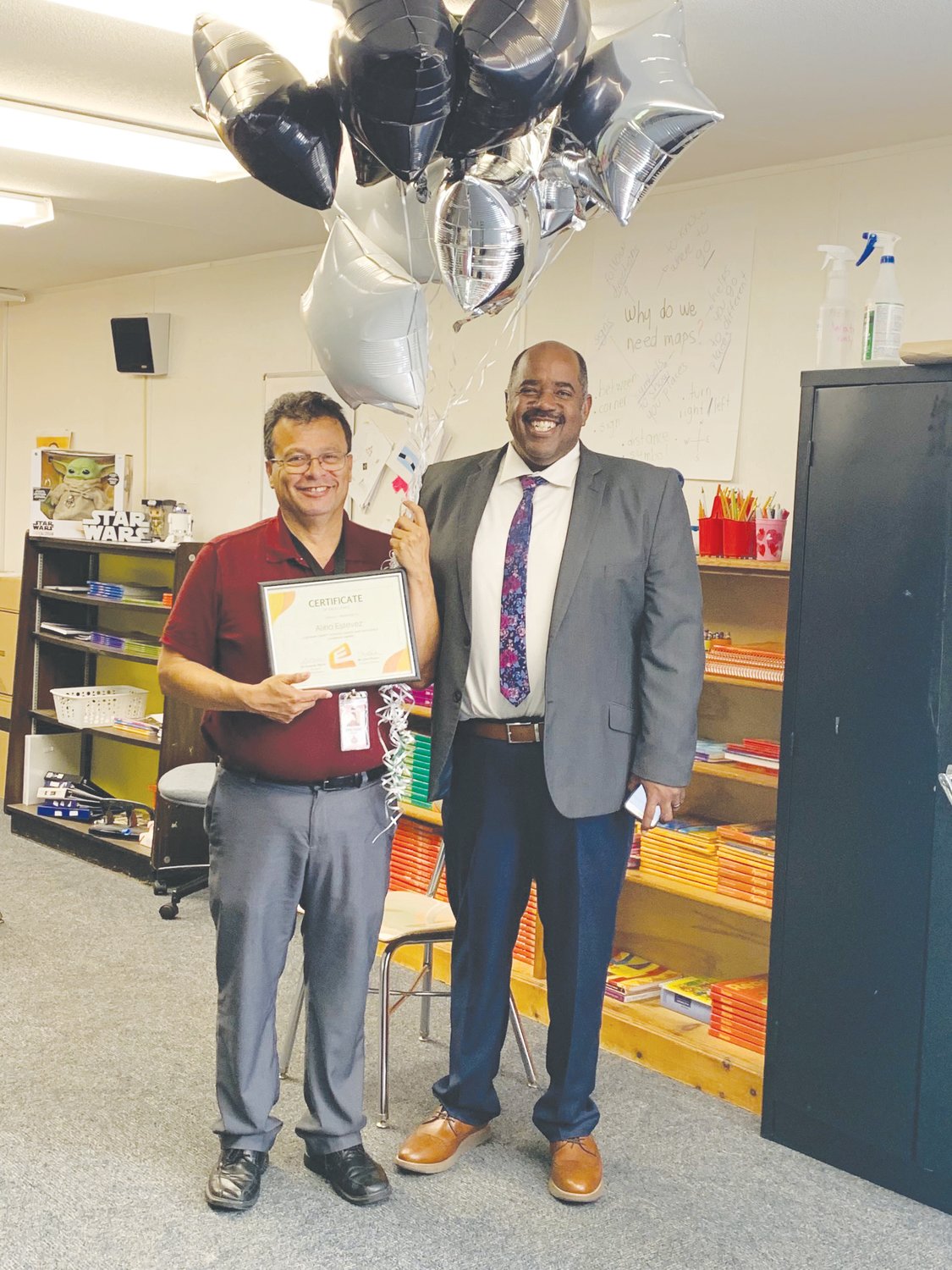 Chris Poston (right), Chatham County Schools’ executive director for excellence and opportunity, recognizes Siler City Elementary School ESL teacher Alirio Estevez as the district's April Equity Champion of the Month.
