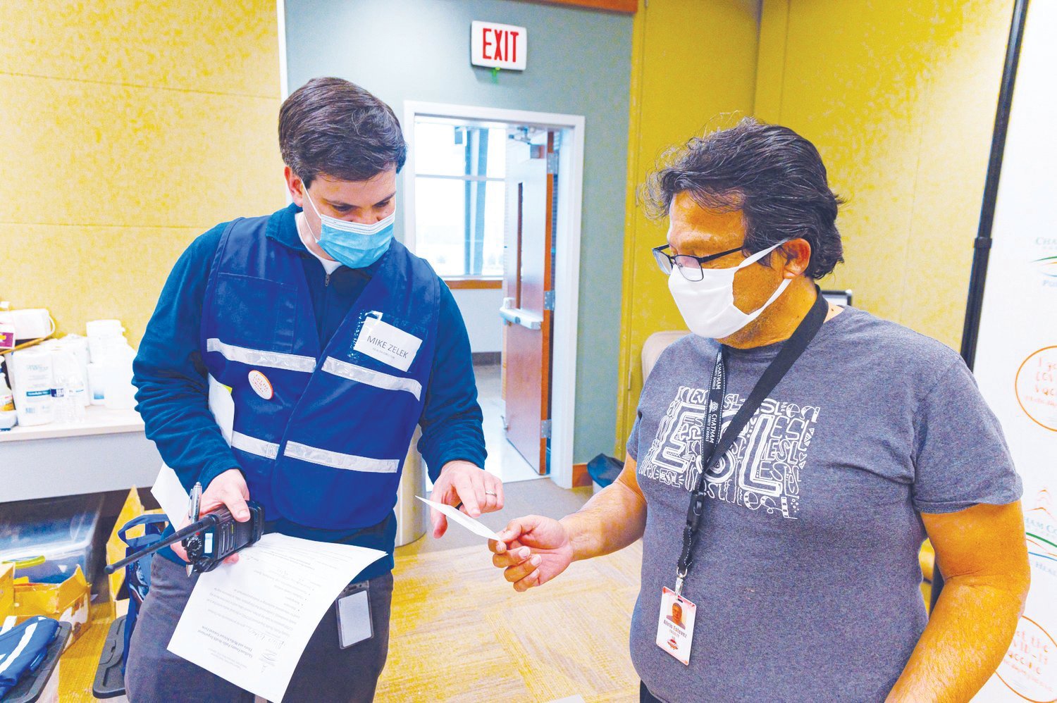 Chatham County Public Health Director Mike Zelek hands Alirio Estevez his second-dose appointment slip during a vaccination clinic last spring.