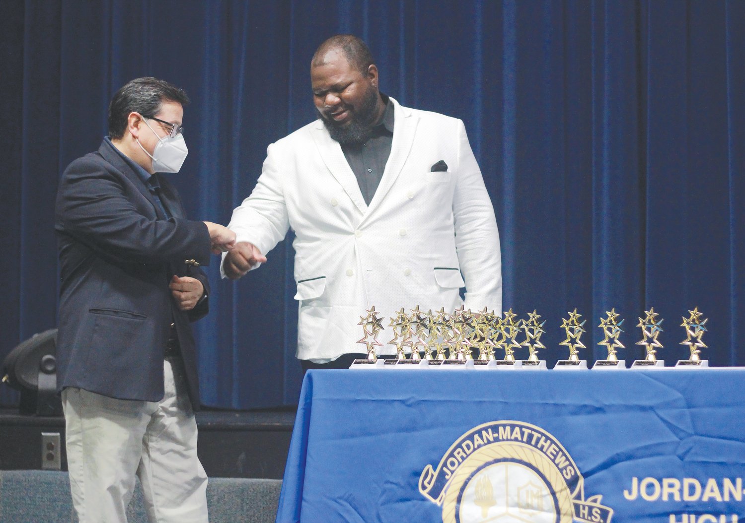 Jordan-Matthews men's soccer head coach Paul Cuadros (left) fist bumps Lamont Piggie, the women's basketball and track & field head coach, during The Jetties ceremony on May 31. Piggie took home the award for Coach of the Year.