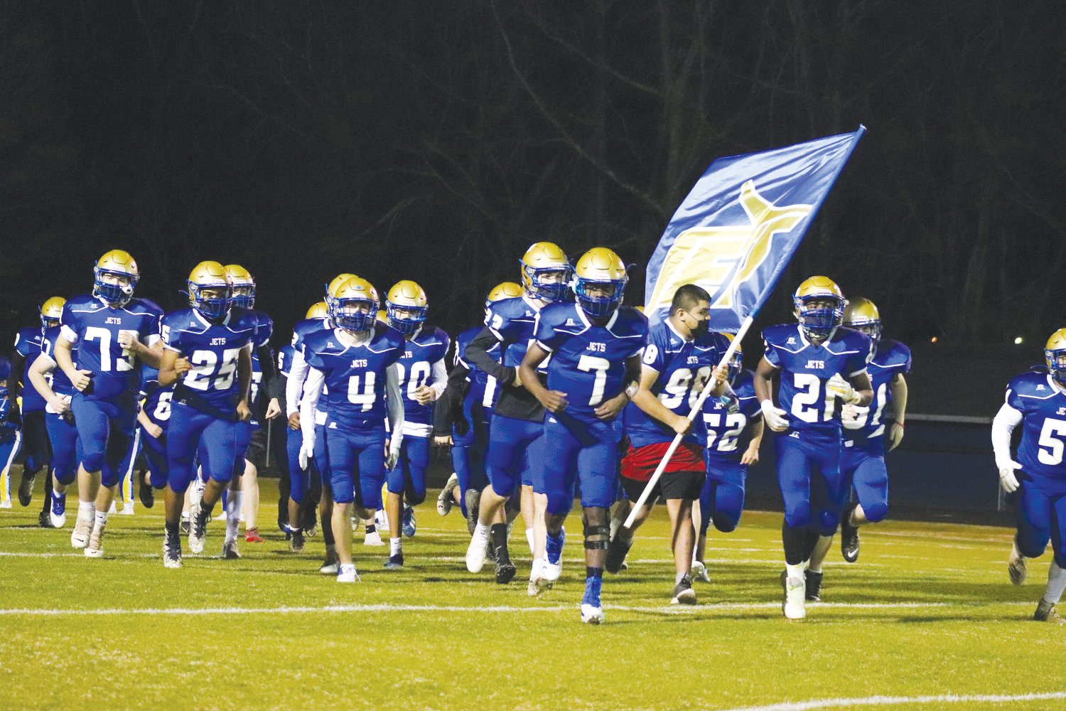Led by senior quarterback Xavier Woods (7), the Jordan-Matthews' football team runs onto the field ahead of their 56-6 loss to Randleman on March 12, 2021. The new Siler City 14U Jets will act as a feeder program for J-M.