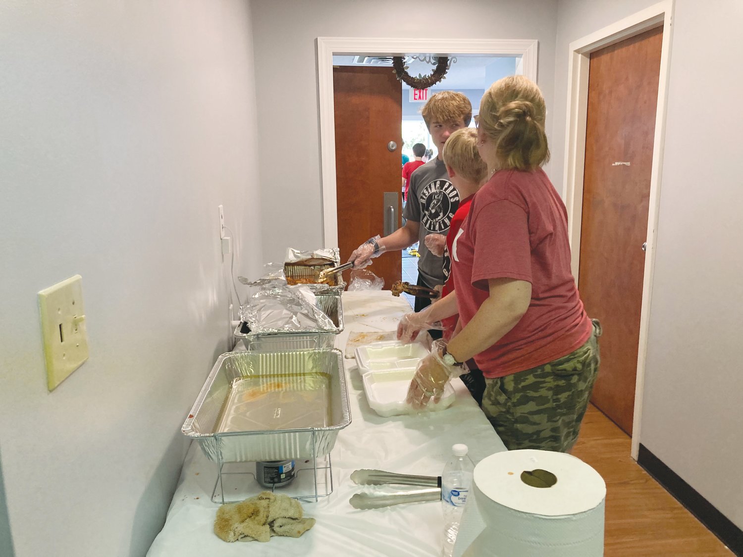 Volunteers work to plate chicken at Love Chatham's fundraiser on Saturday.