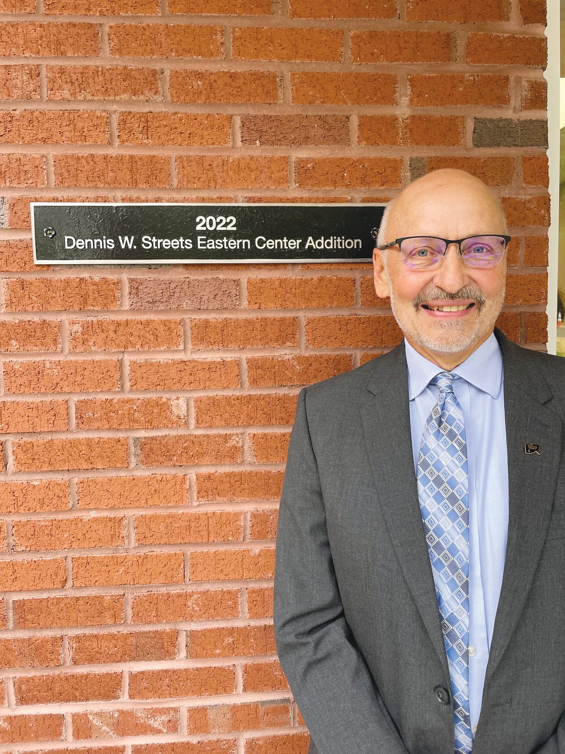 Retired Chatham County Council on Aging Director Dennis Streets stands next to the plaque proclaiming the Eastern Chatham Senior Center addition as the ‘Dennis W. Streets Eastern Center Addition’ last Friday in Pittsboro.