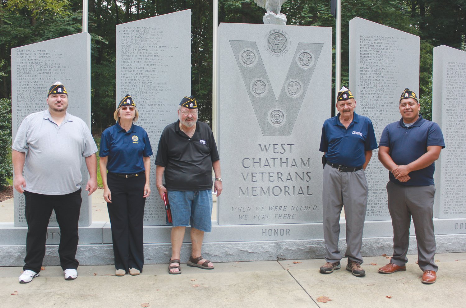 Members of the American Legion Post 93, including Vice Commander Scott Busenlehner (far left) and Commander Carin O’Brien (second from left), pose for a group portrait next to the West Chatham Veterans Memorial at Bray Park in Siler City. This year, Post 93 will be celebrating its 100th anniversary as an organization for veterans.