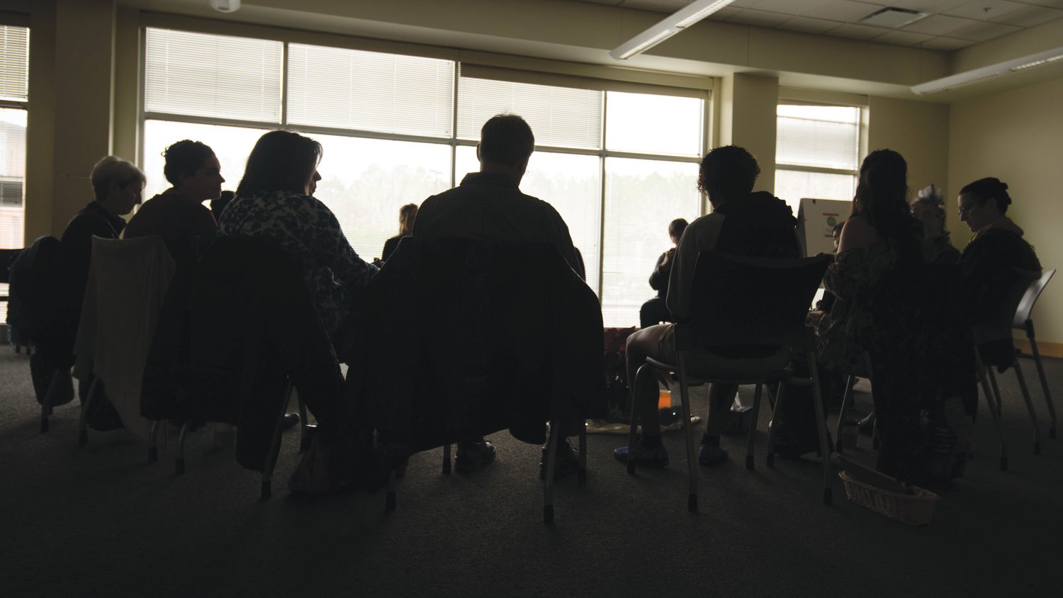 Attendees cast silhouettes during a conversation regarding death and grief. Around a dozen people shared stories during Death and Cupcakes on Saturday morning at the Chatham Community Library.